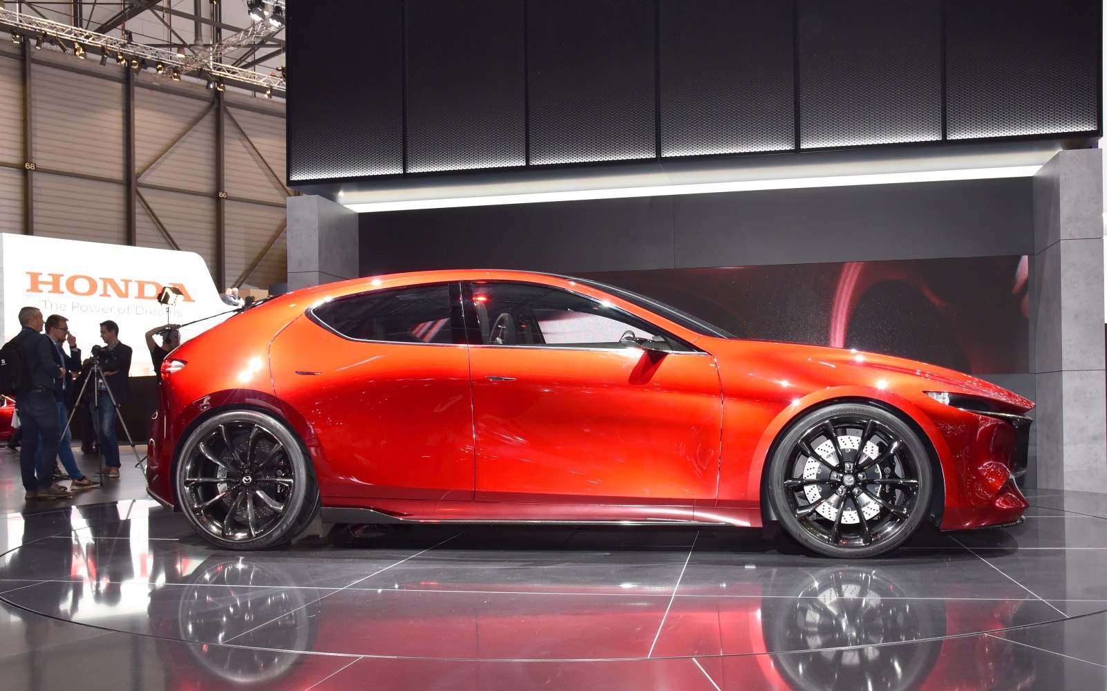 Red compact hatchback with tinted windows and large black alloy wheels