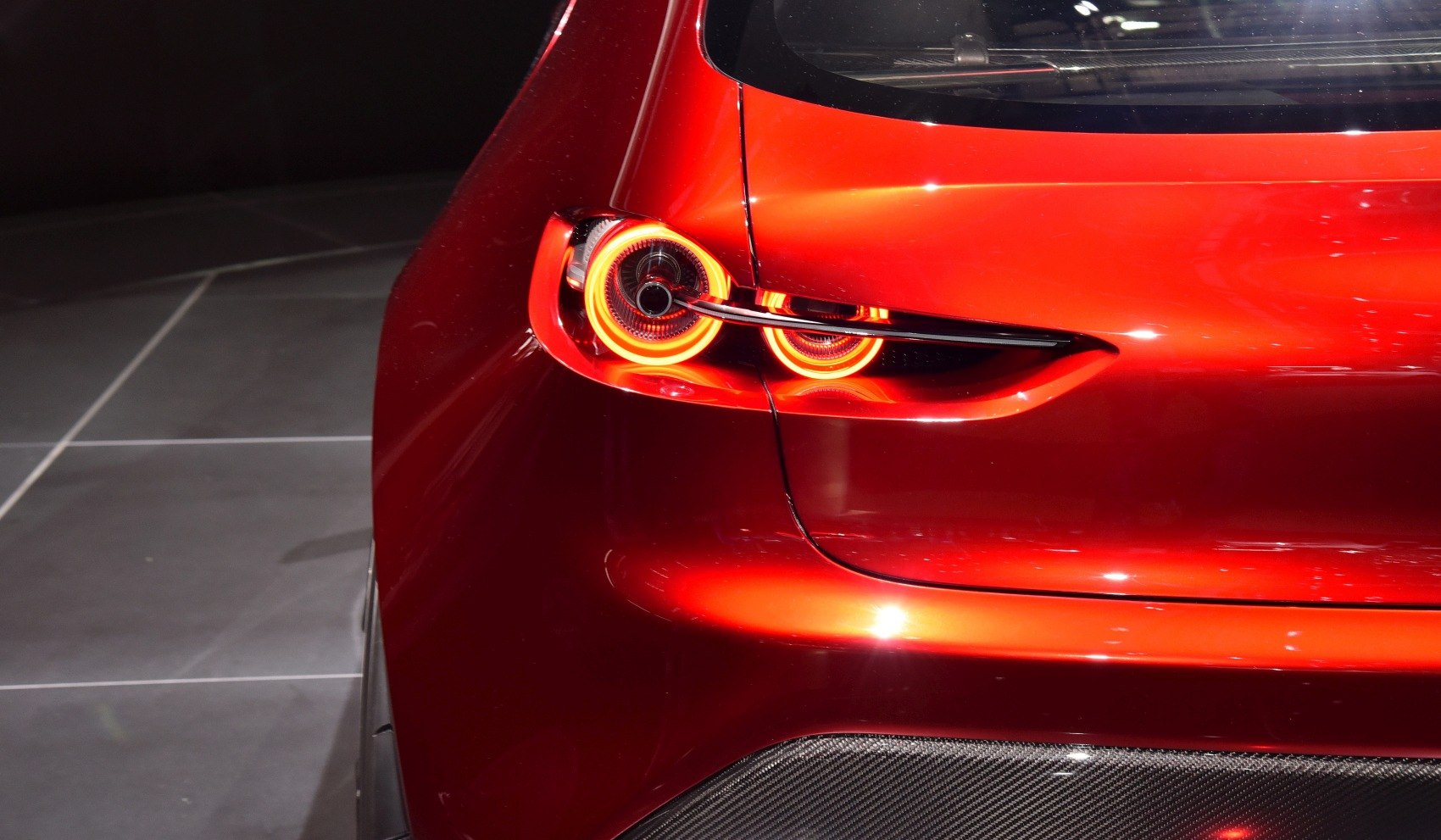 Close-up of futuristic LED rear light cluster with sleek red body panel