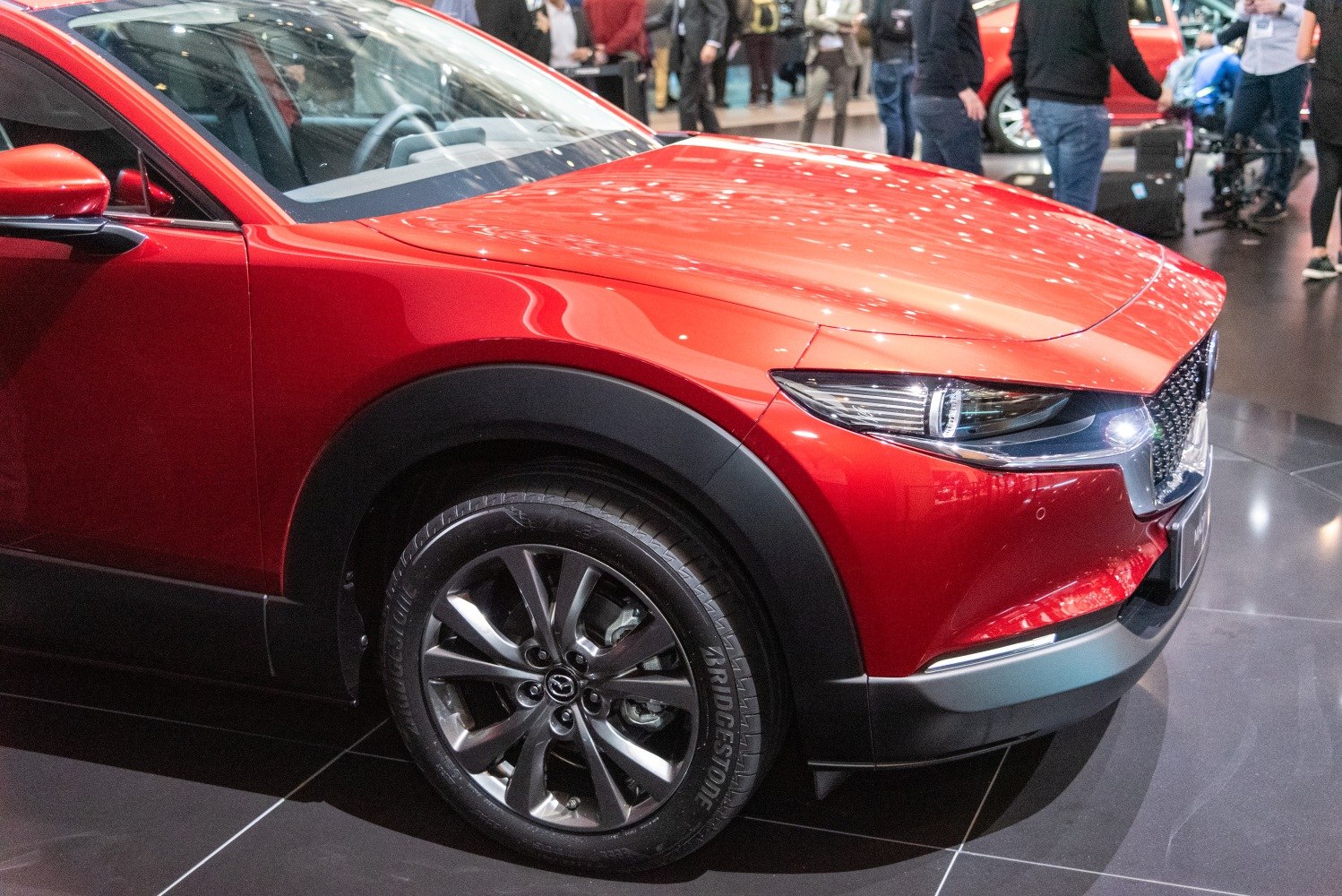 Front side view showing headlight and wheel of red vehicle