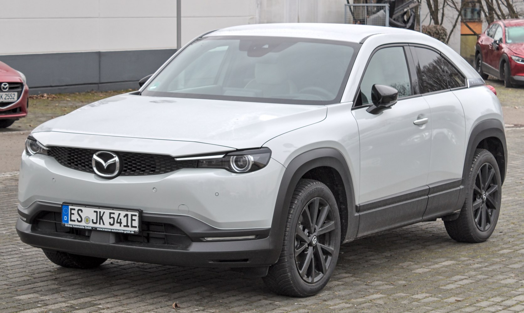 Front and side view of SUV with sleek headlights and aerodynamic body design