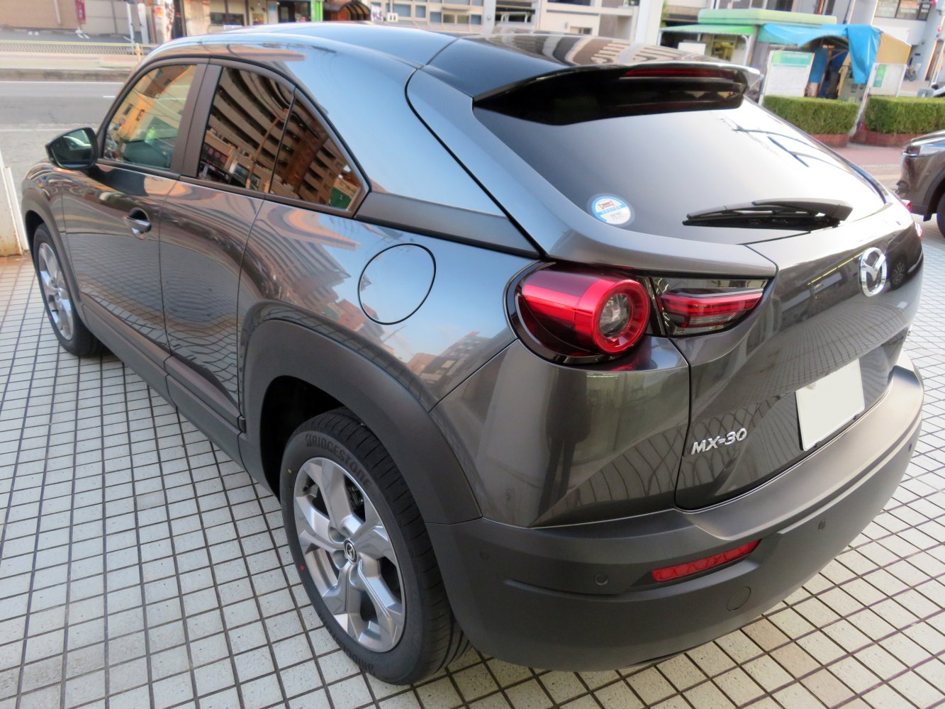 Rear view showing round tail lights and glossy black roof