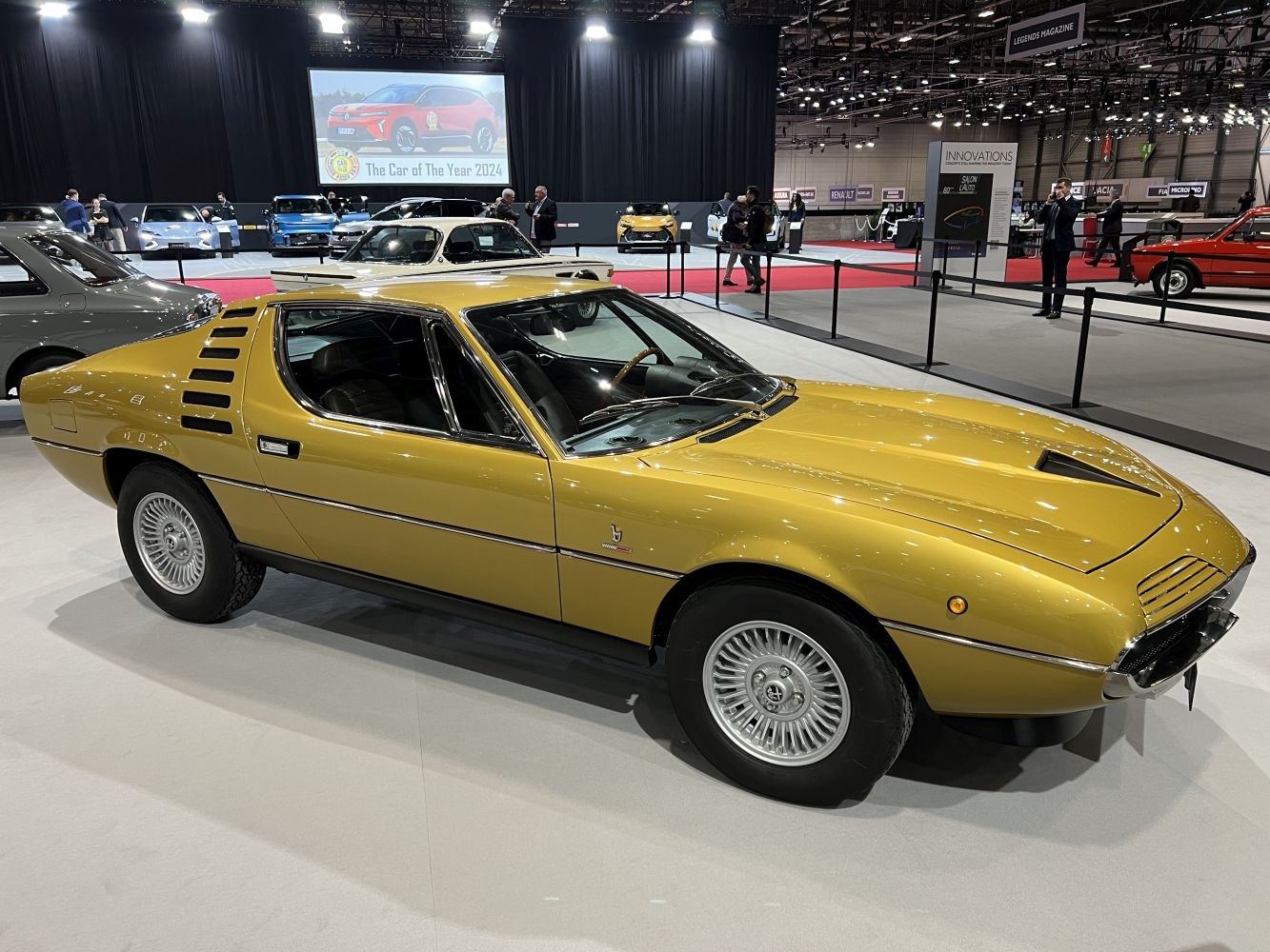 Vintage sports coupe with rear quarter louvers and distinctive front hood vents.