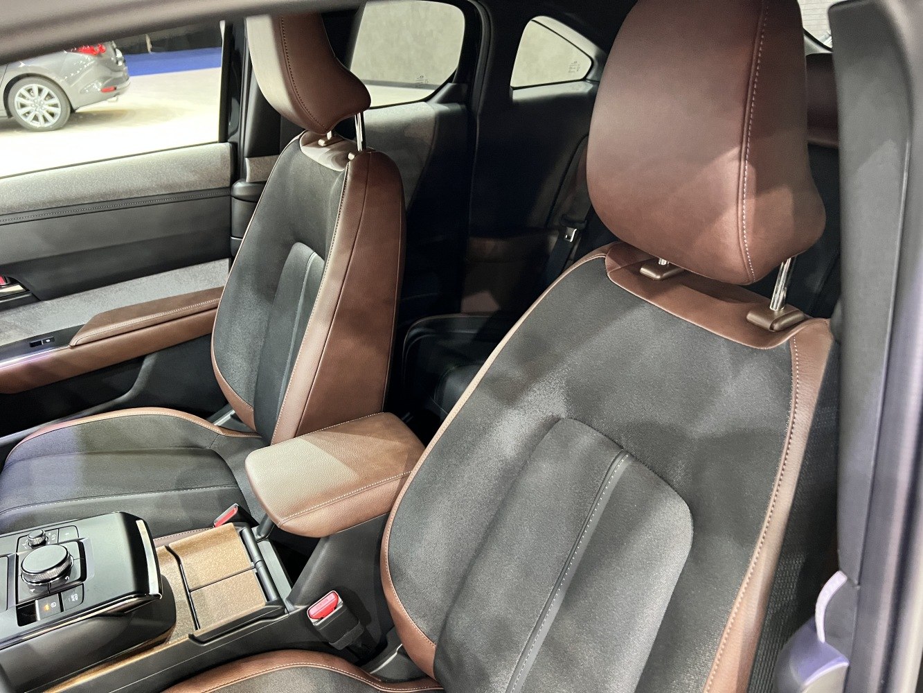 Two-tone brown and black front seats with center console and armrest.