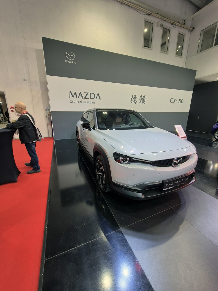 Front view of white electric compact SUV at auto show