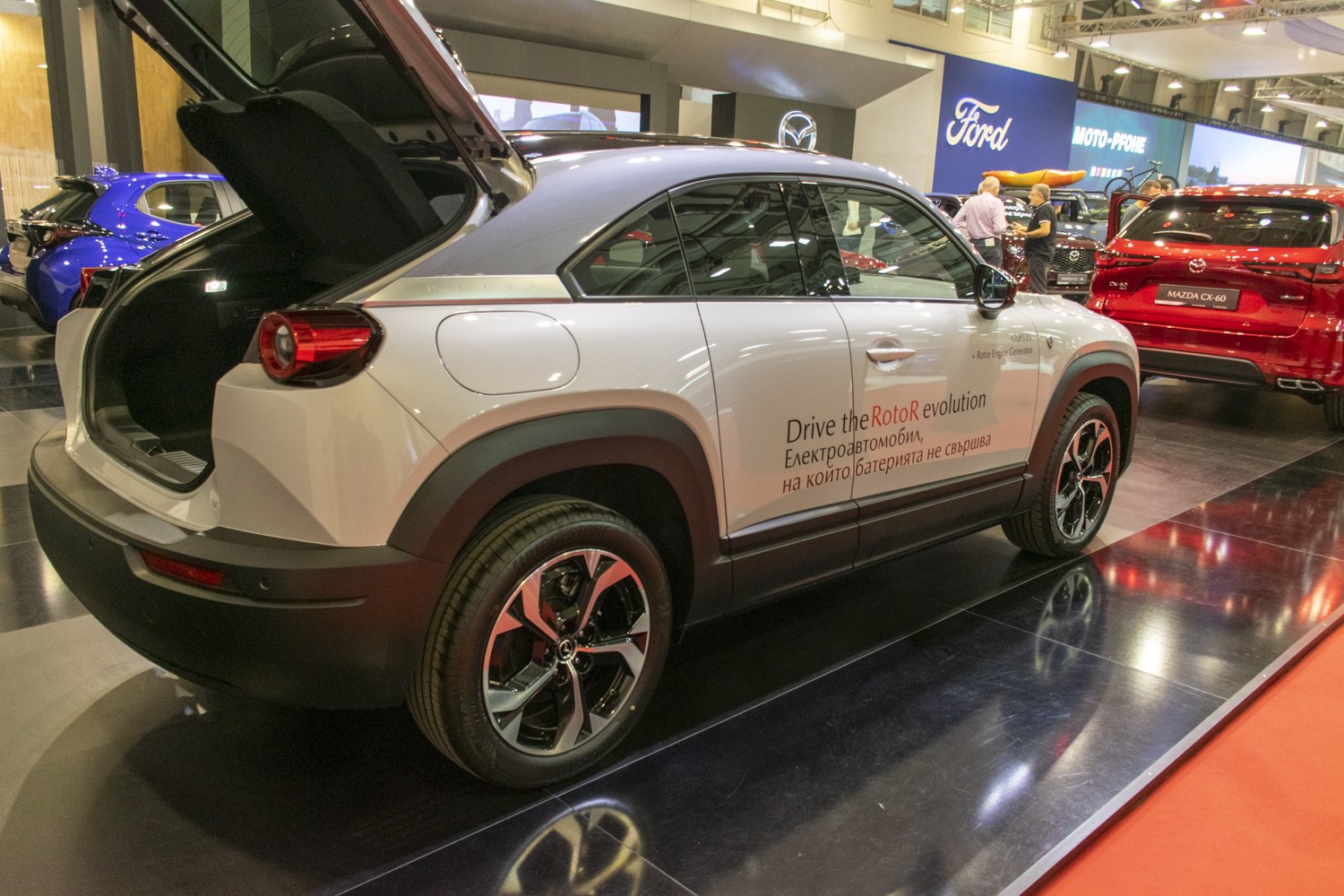 Rear side view of electric SUV with open trunk and alloy wheels