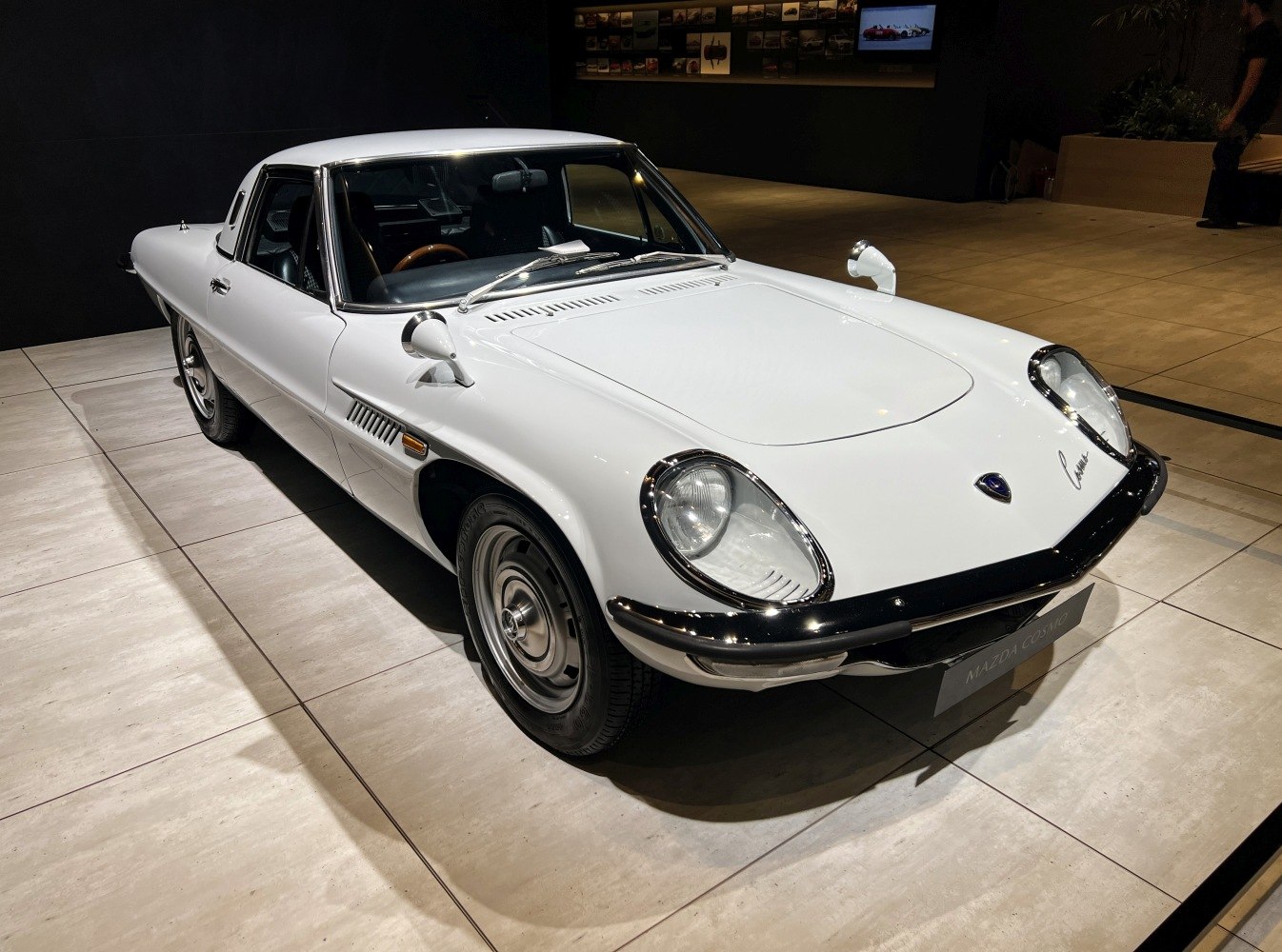 White vintage coupe with round headlights and side mirrors on fenders