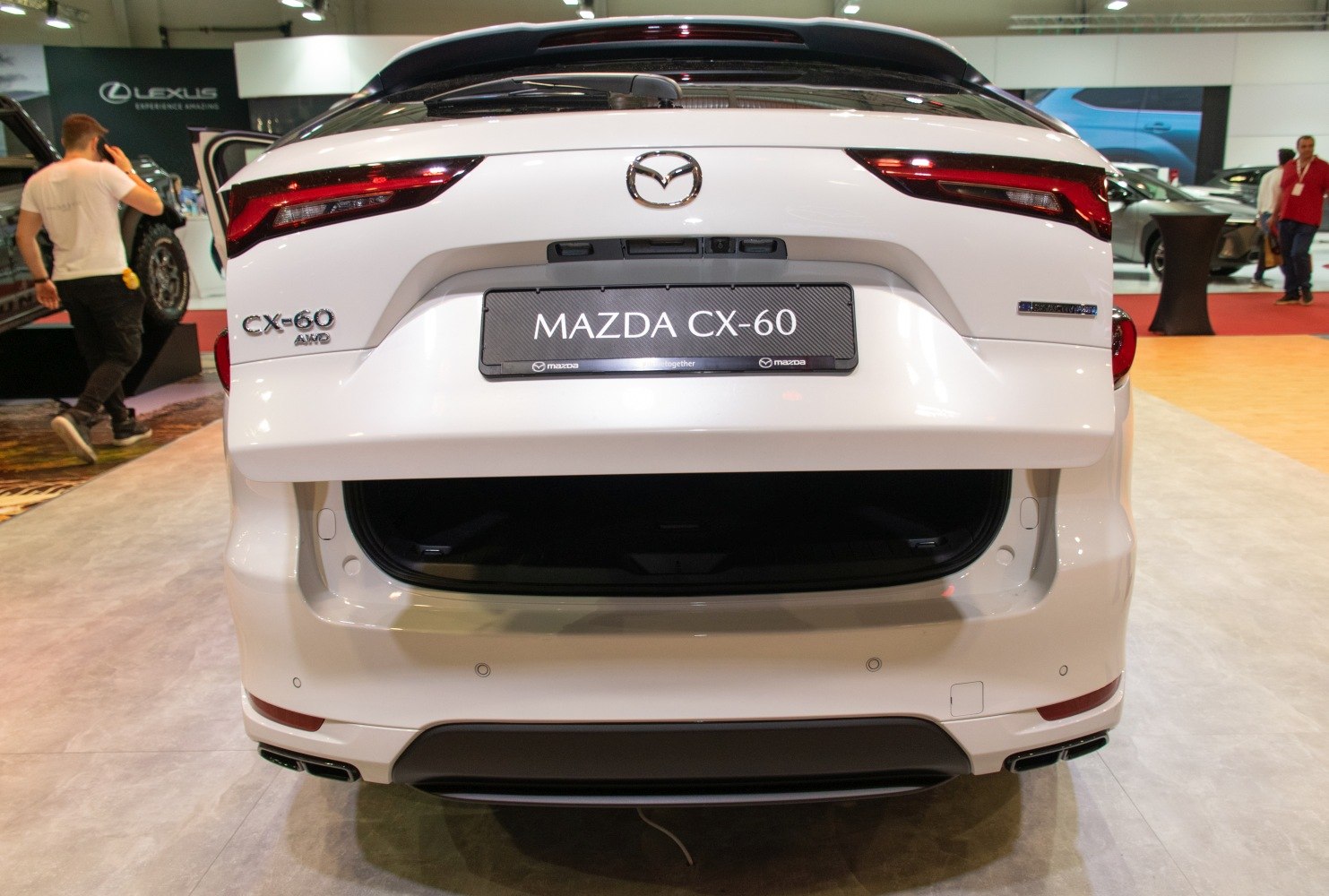 Rear view of white Mazda CX-60 with open trunk and modern taillights