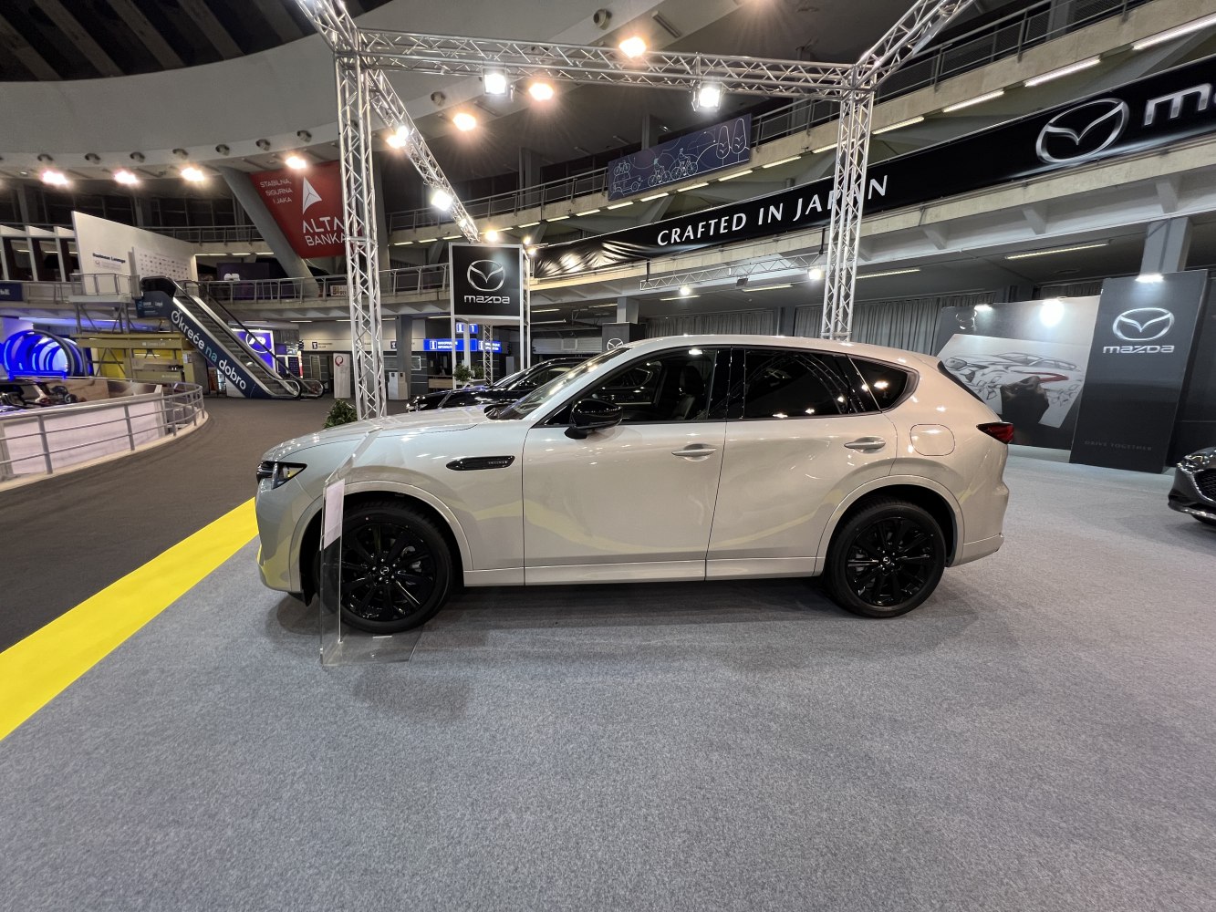 Side profile of SUV with black alloy wheels on display.