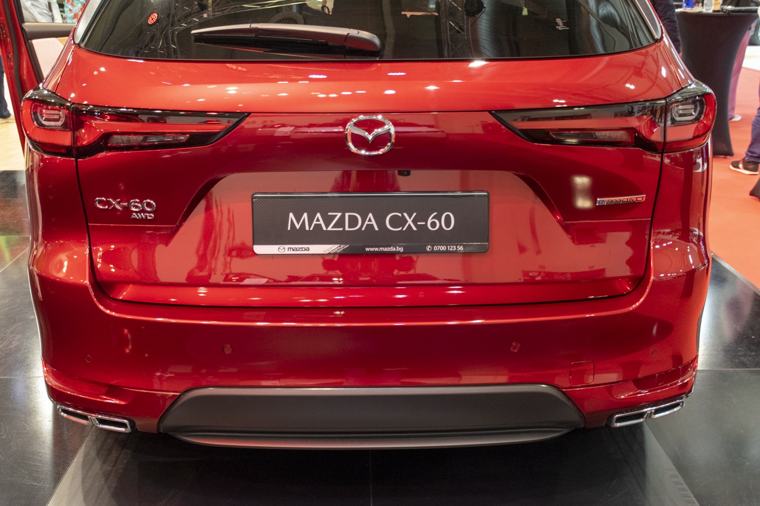 Red rear end with tail lights, Mazda badge, AWD emblem, and dual exhausts