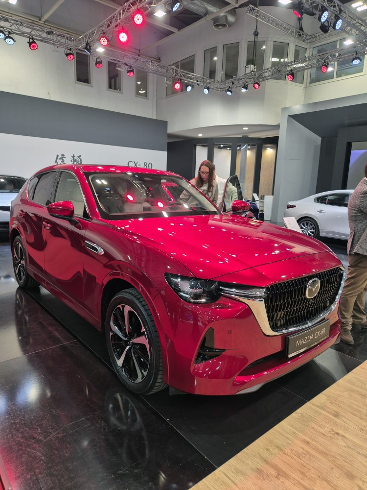 Red SUV front with bold grille and sleek headlights at car show
