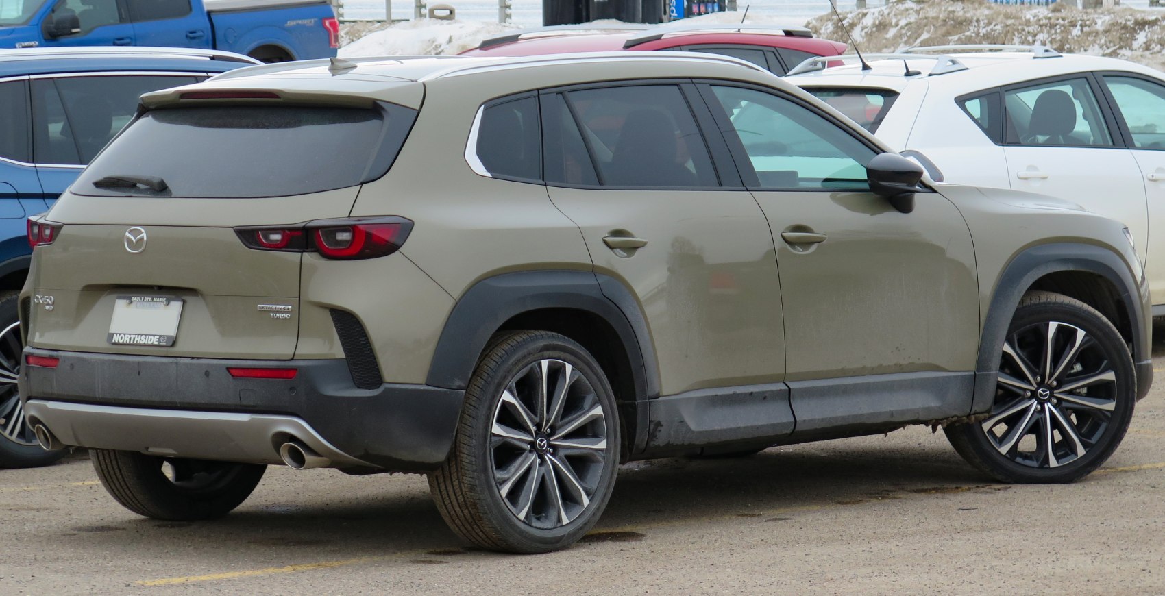 Rear side view with dual exhaust and alloy wheels