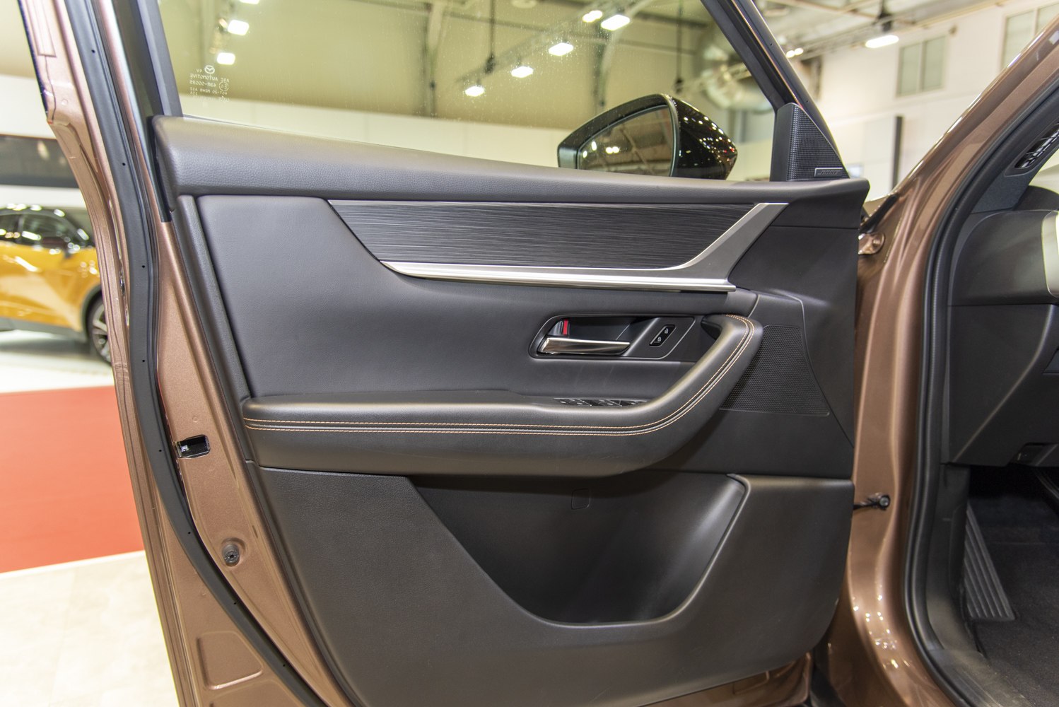 Car door panel with stitched armrest and integrated controls