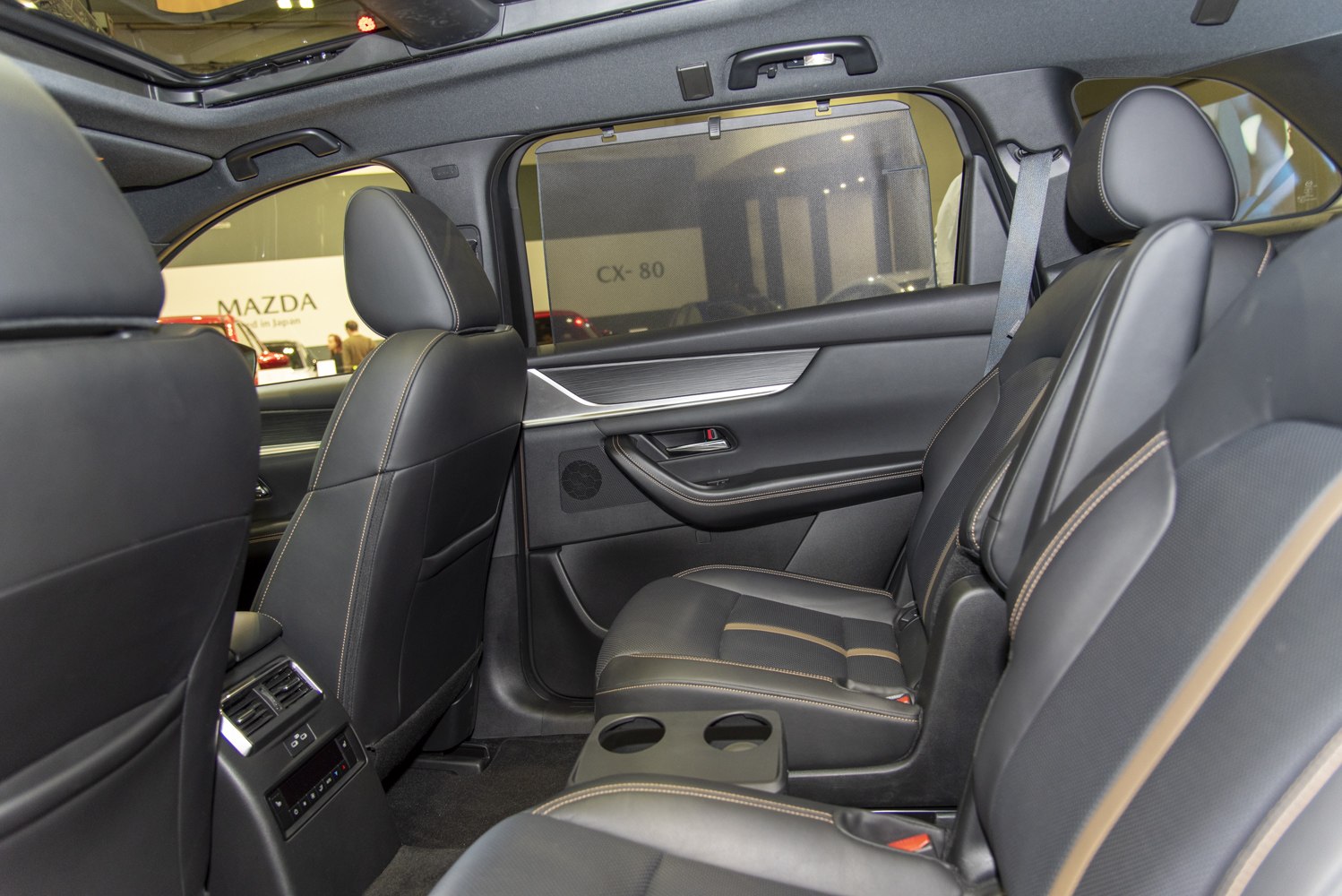 Rear luxurious leather seats with detailed stitching and rear climate controls.