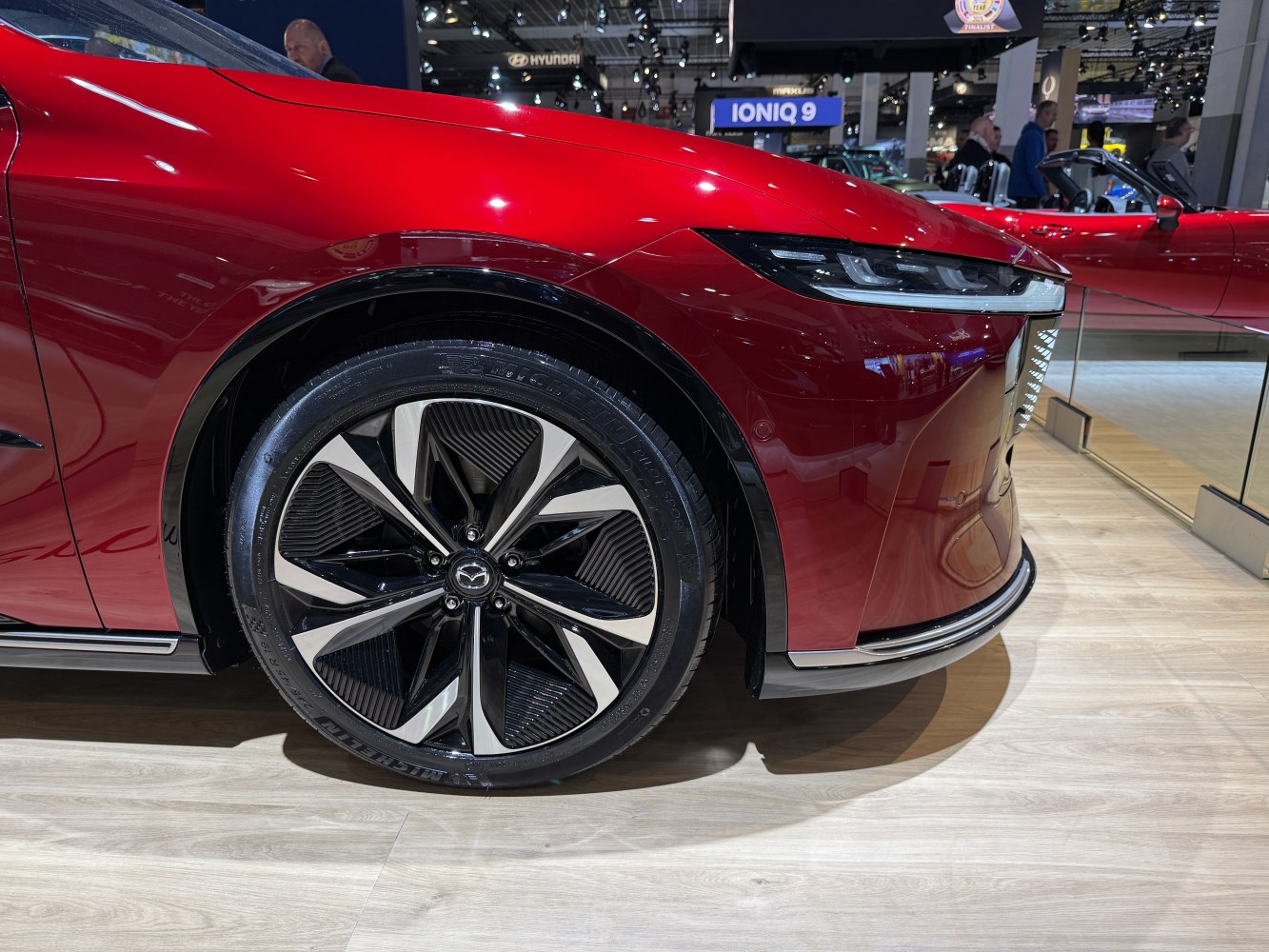 Close-up of alloy front wheel and sleek LED headlight.