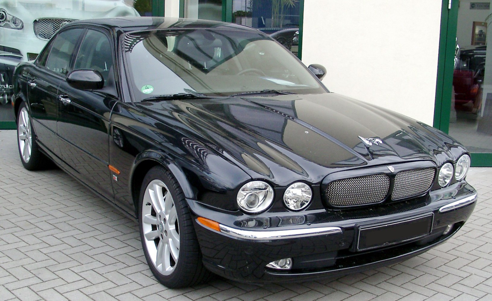 Luxury sedan front with quad round headlights and mesh grille