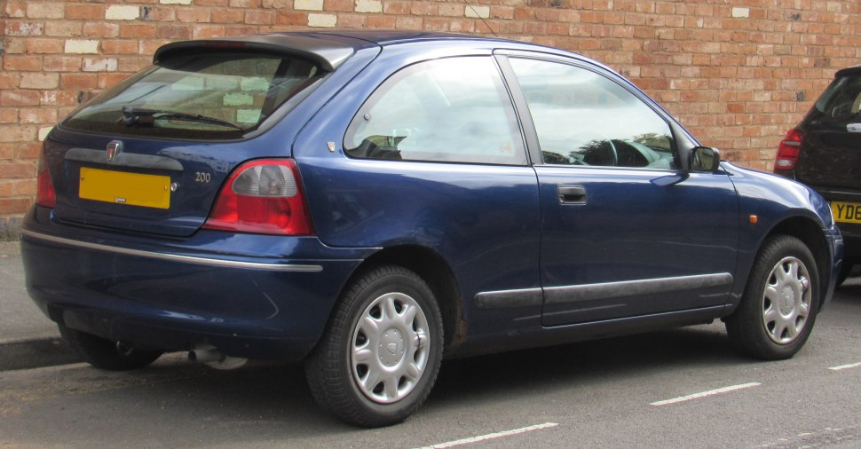 Rear-side view of a 1990s compact hatchback with rear spoiler and alloy wheels