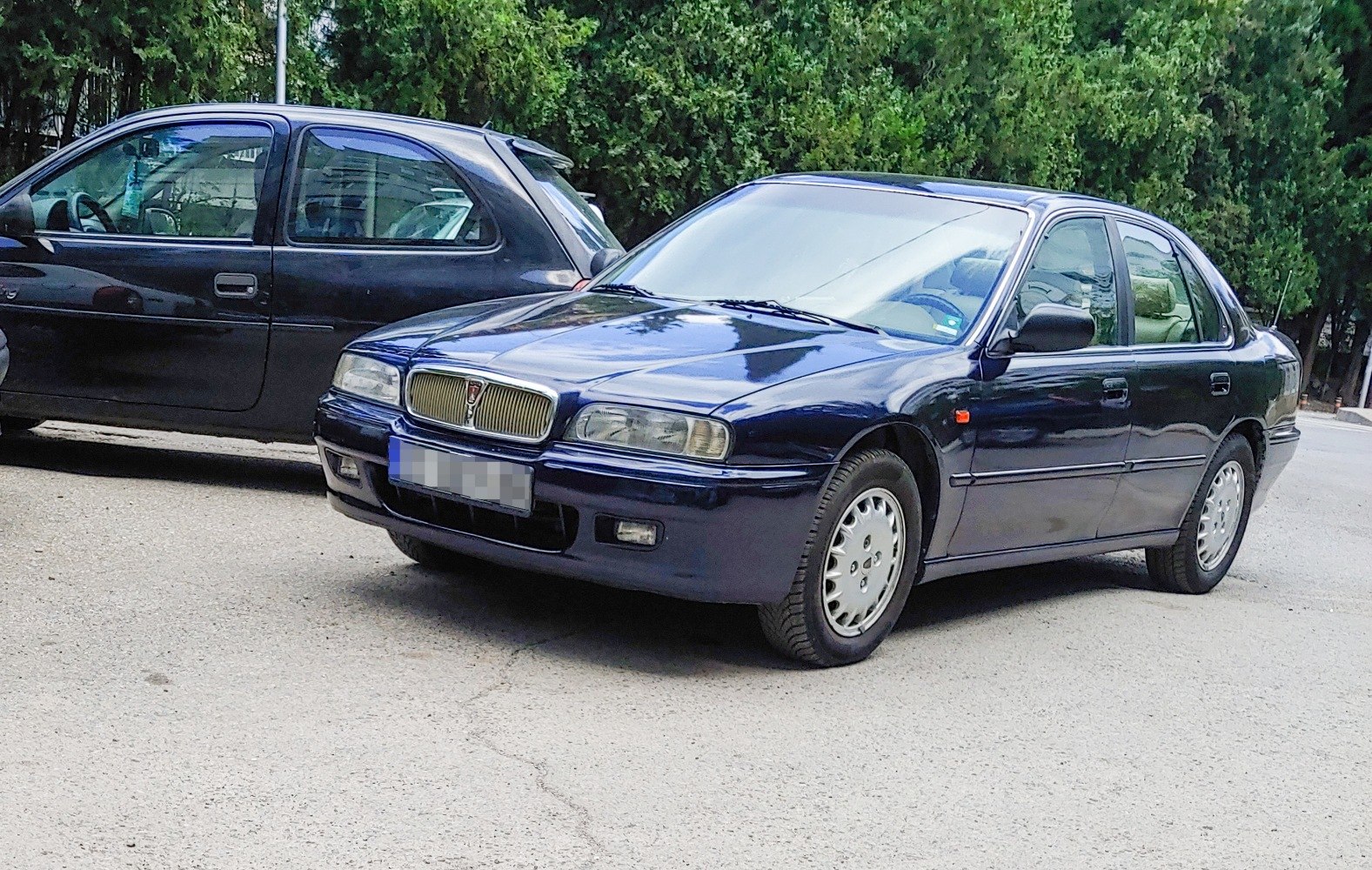 Mid-90s four-door sedan with vertical slat grille and alloy wheels