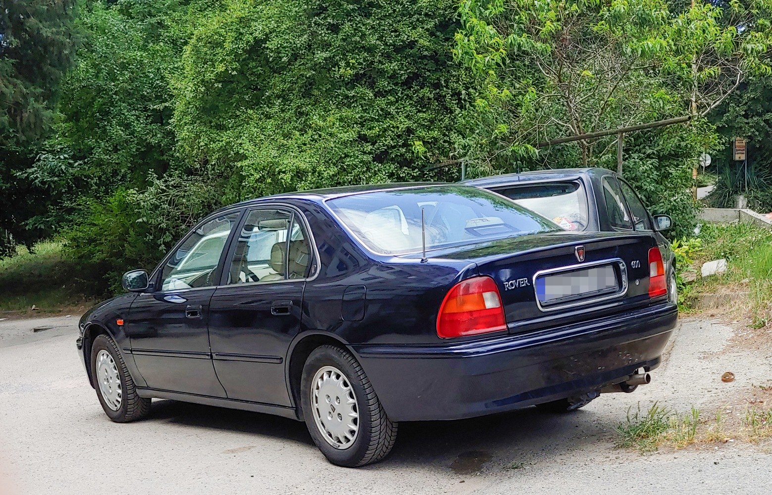Rear side view of a classic four-door sedan with distinct tail lights and smooth body lines