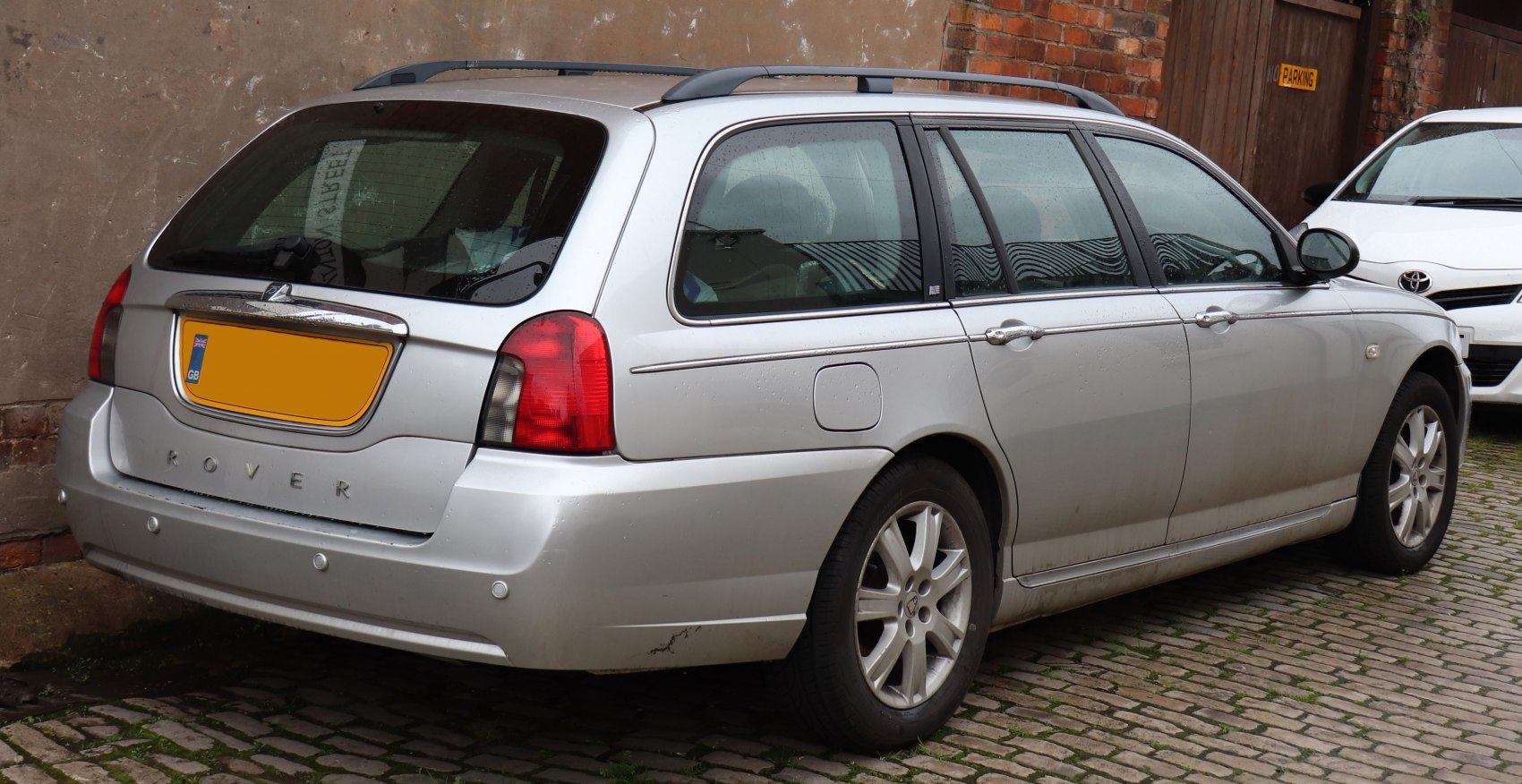 Silver station wagon rear-side view with roof rails and alloy wheels.