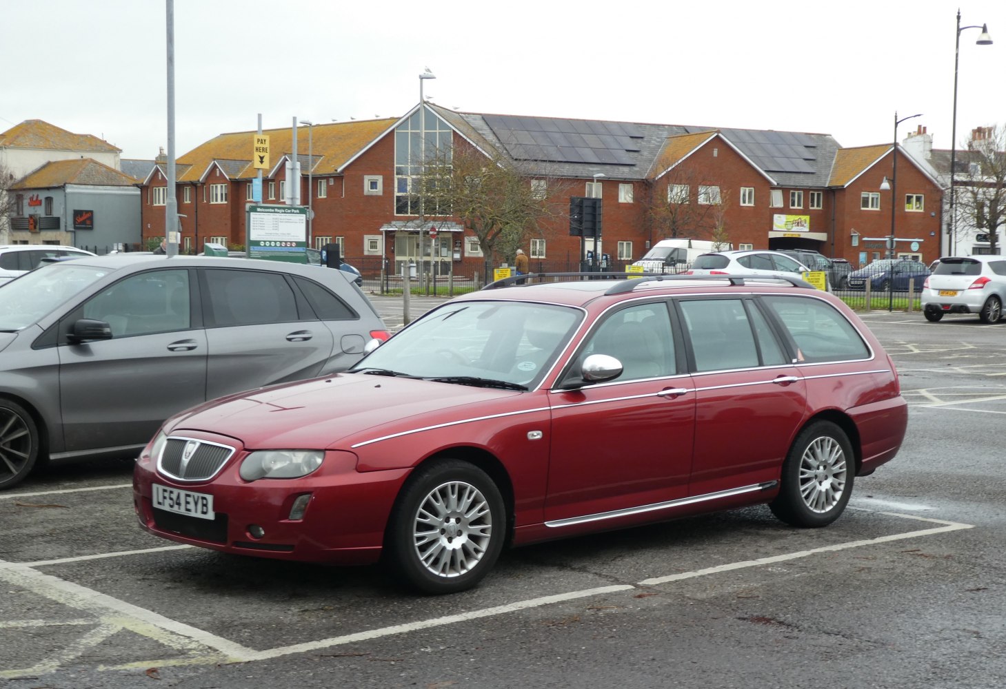 Red estate car with chrome trim and multi-spoke alloy wheels.