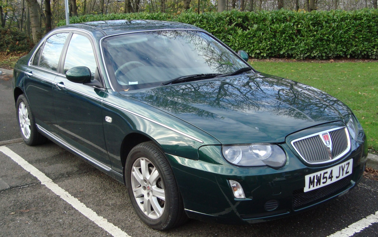 Dark green sedan showcasing front grille and dual rounded headlights.