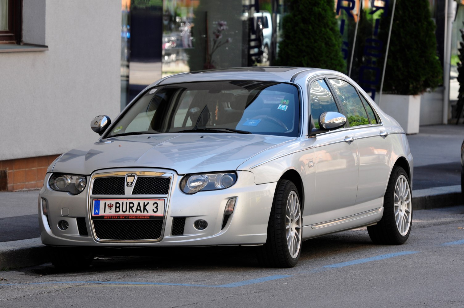 Front and side view of a silver sedan with distinctive grille and alloy wheels