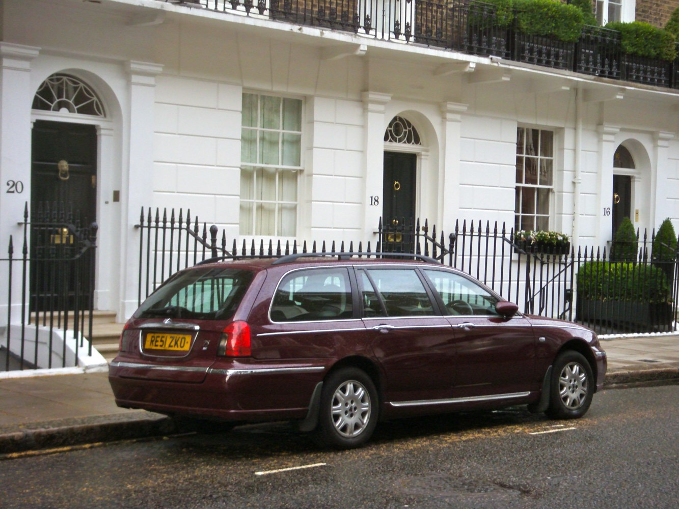 Rear side view of an estate vehicle with distinctive rear light clusters and roof rails.