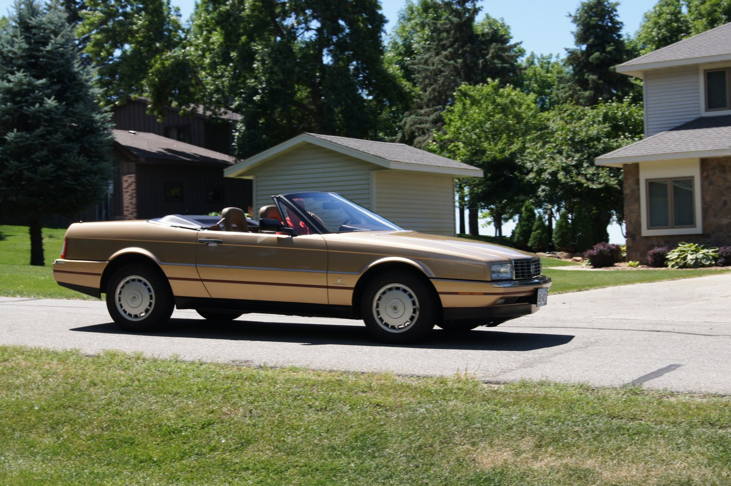 Gold convertible car side profile with classic 1990 design.