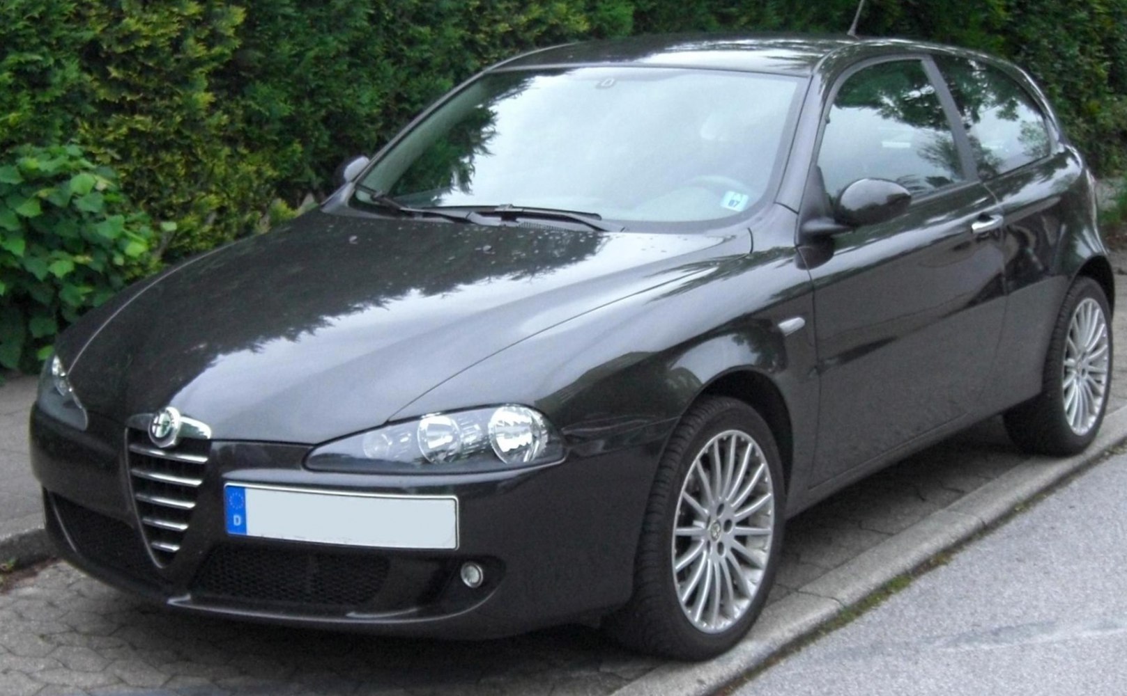 Front and side view of a 3-door compact hatchback with distinctive grille and alloy wheels