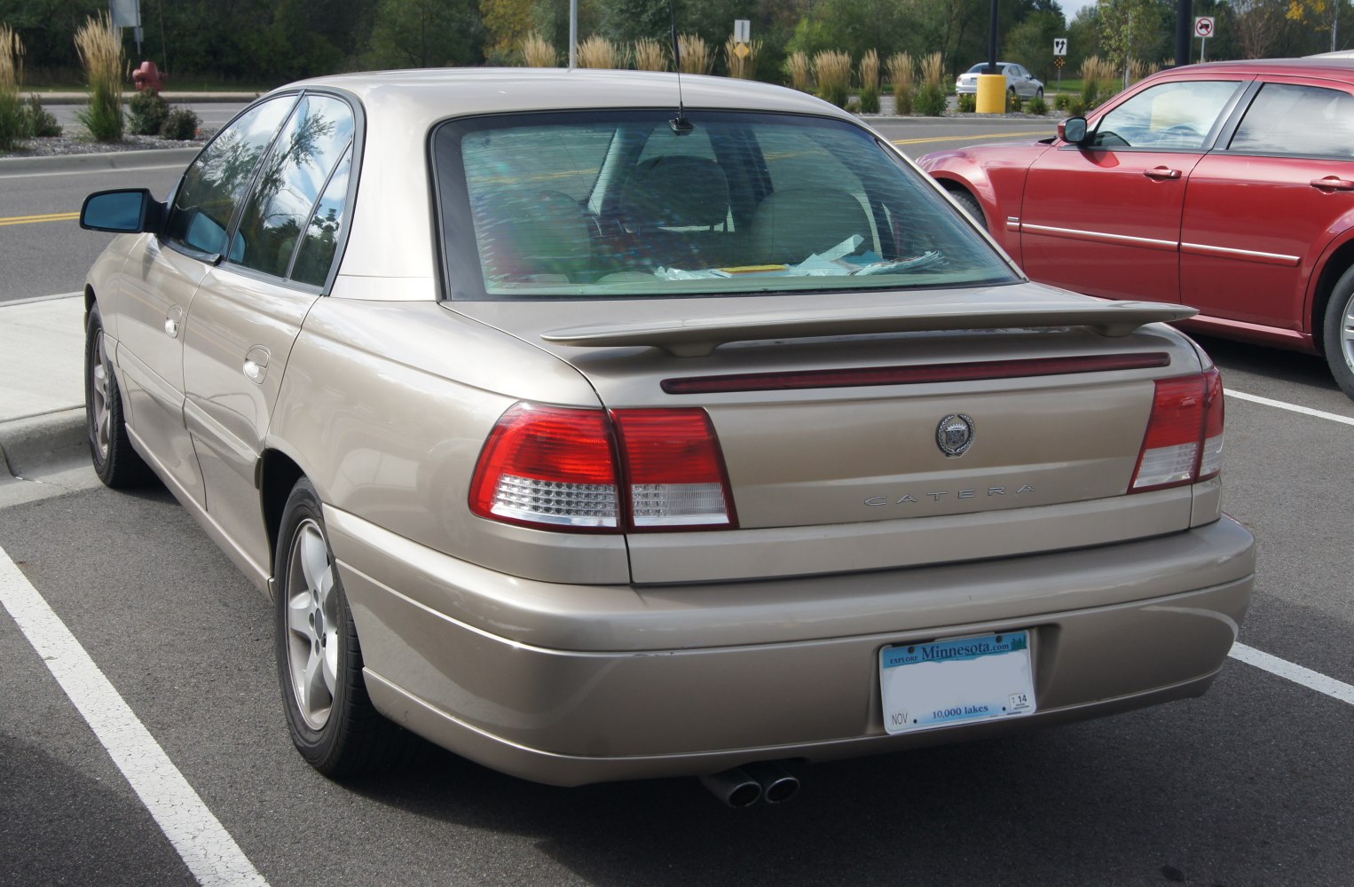 Rear view of sedan with spoiler, dual exhaust, and distinctive taillights
