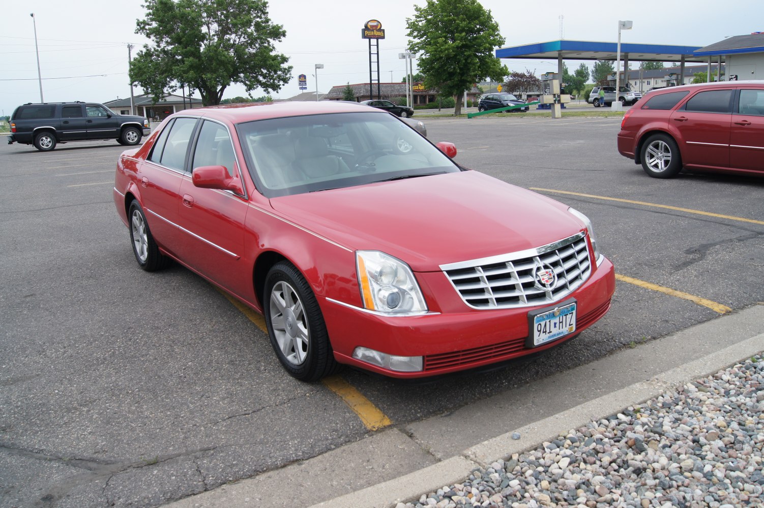 Red luxury sedan emphasizing front chrome grille and headlights