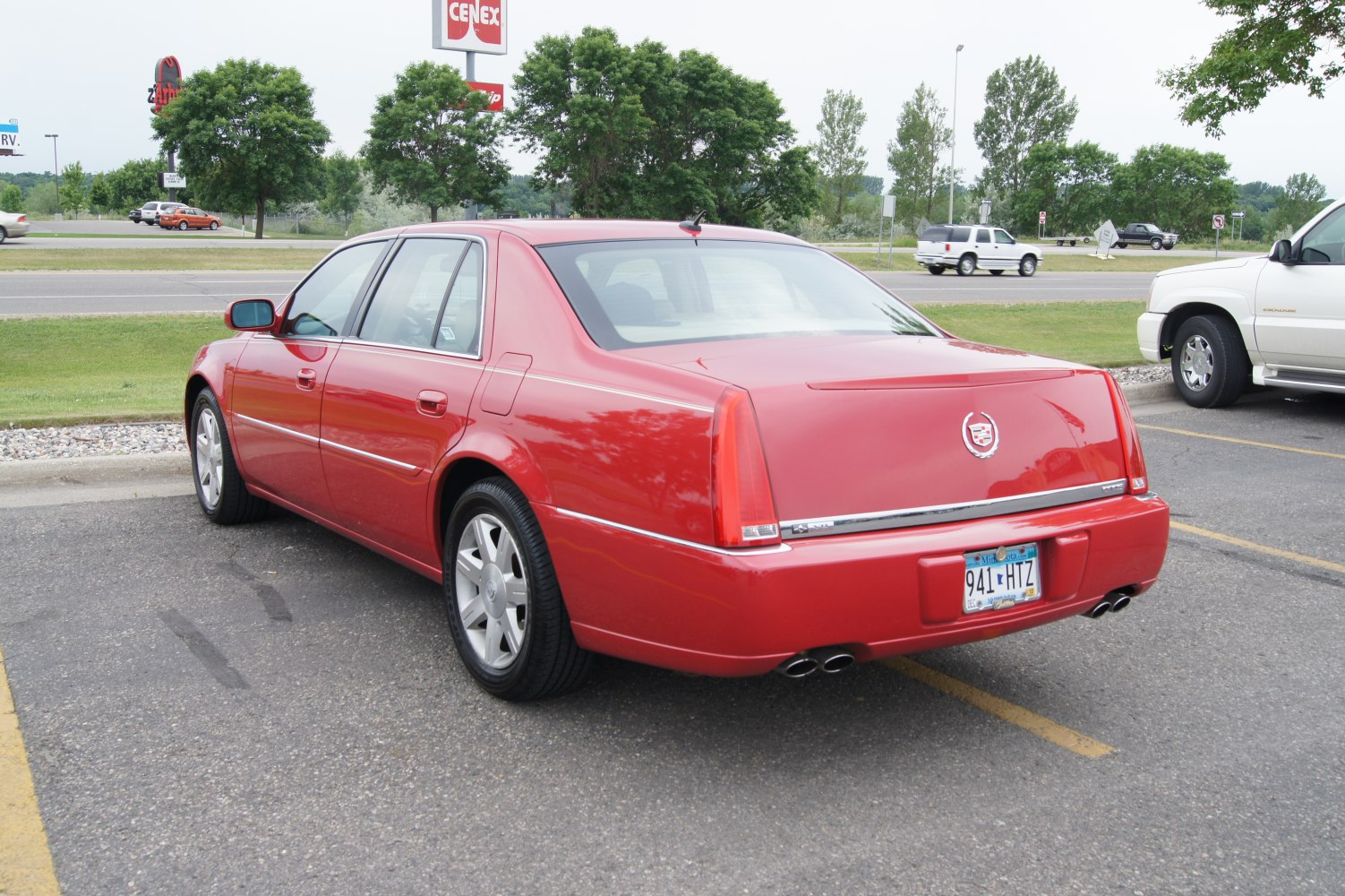 Rear and side view of red luxury sedan with vertical taillights and quad exhaust tips