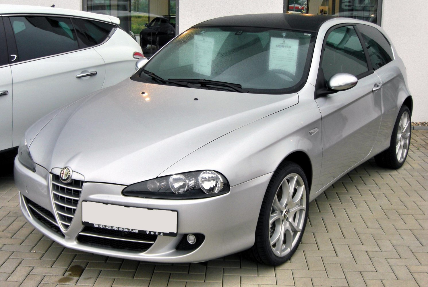 Silver 3-door hatchback with alloy wheels and front grille