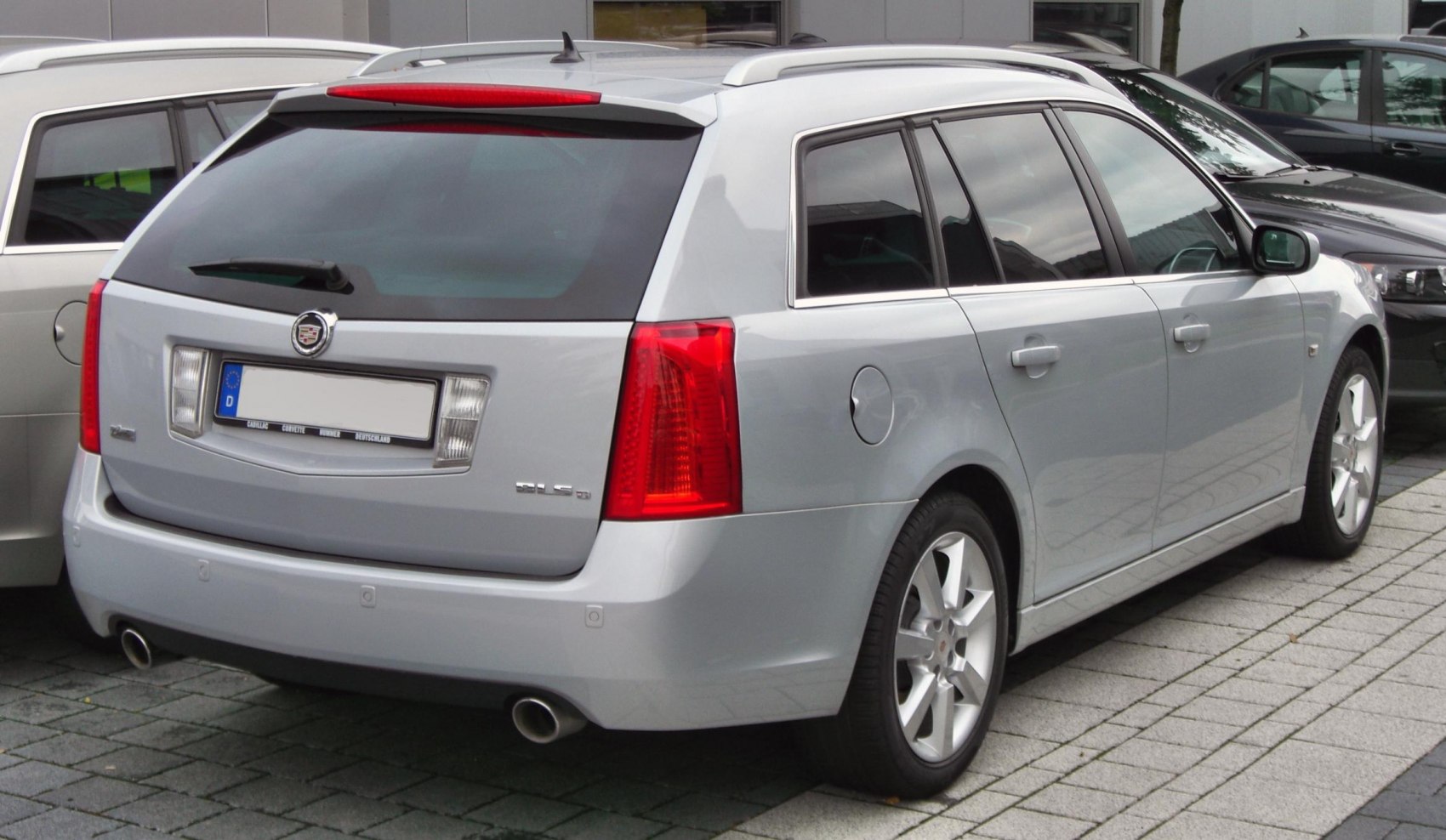 Rear and side view of silver estate car with dual exhaust and distinct tail lights