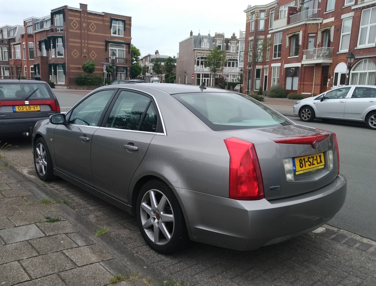 Rear side view of a sedan with distinctive vertical tail lights and alloy wheels.