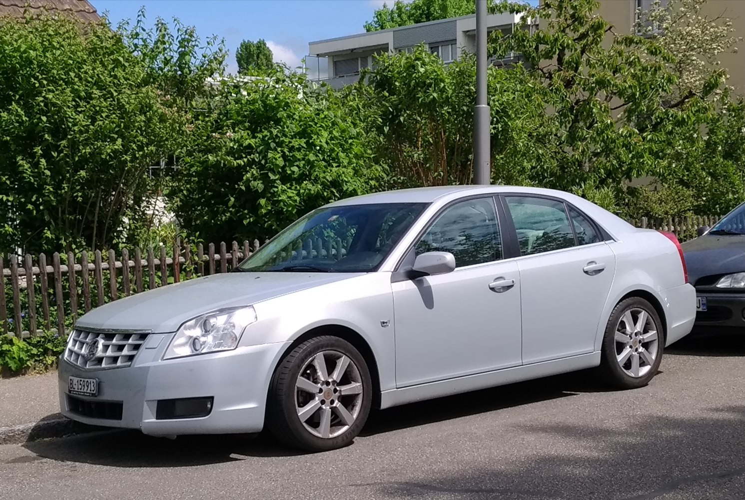 Silver sedan with multi-spoke alloy wheels and LED headlights.