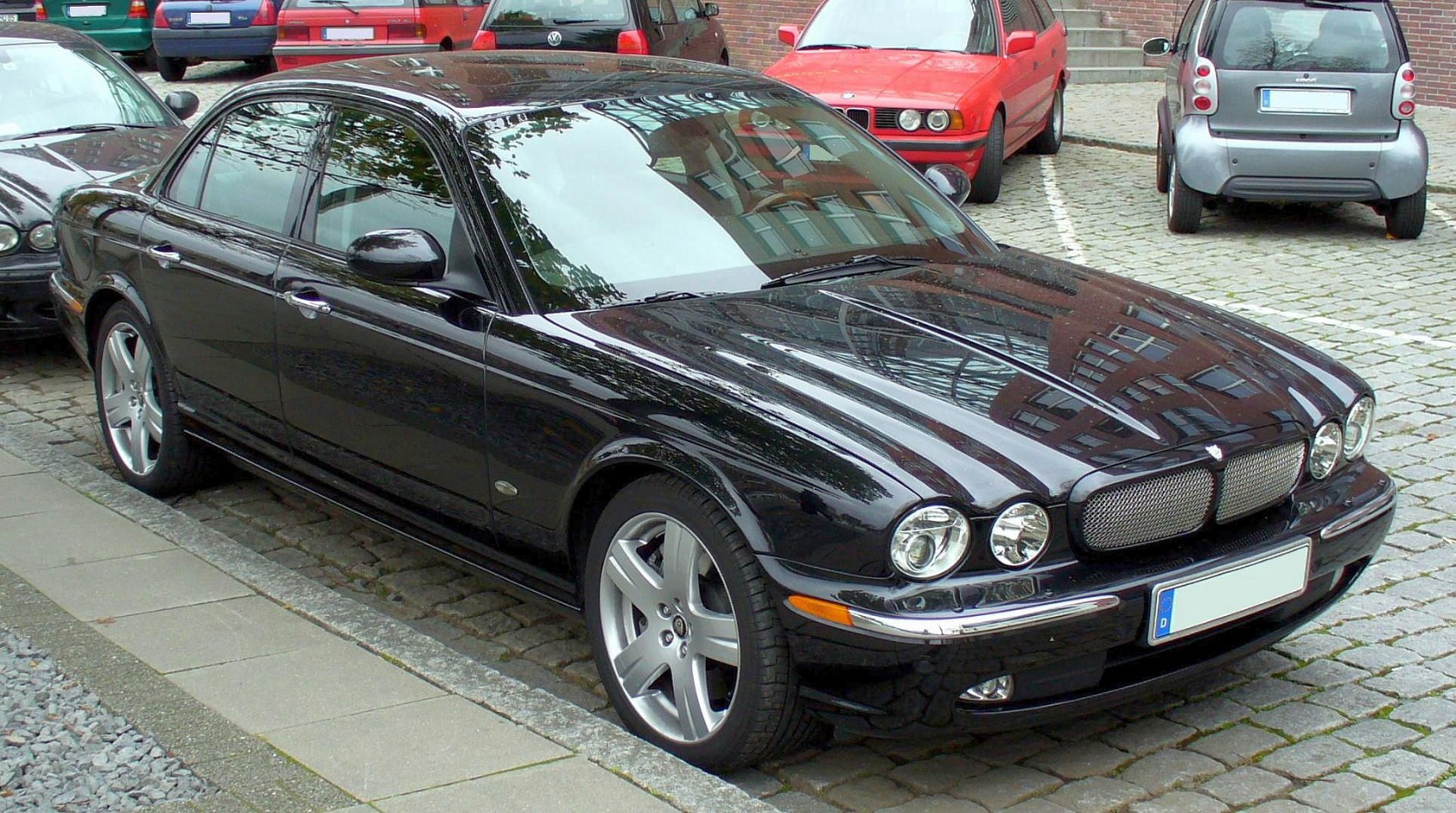Luxury sedan front side with dual round headlights and alloy wheels