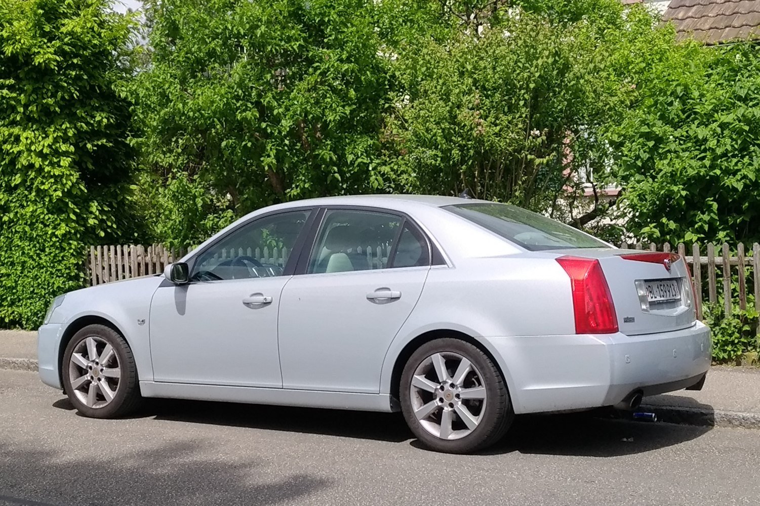 Silver sedan side profile with angular rear lights and five-spoke alloy wheels