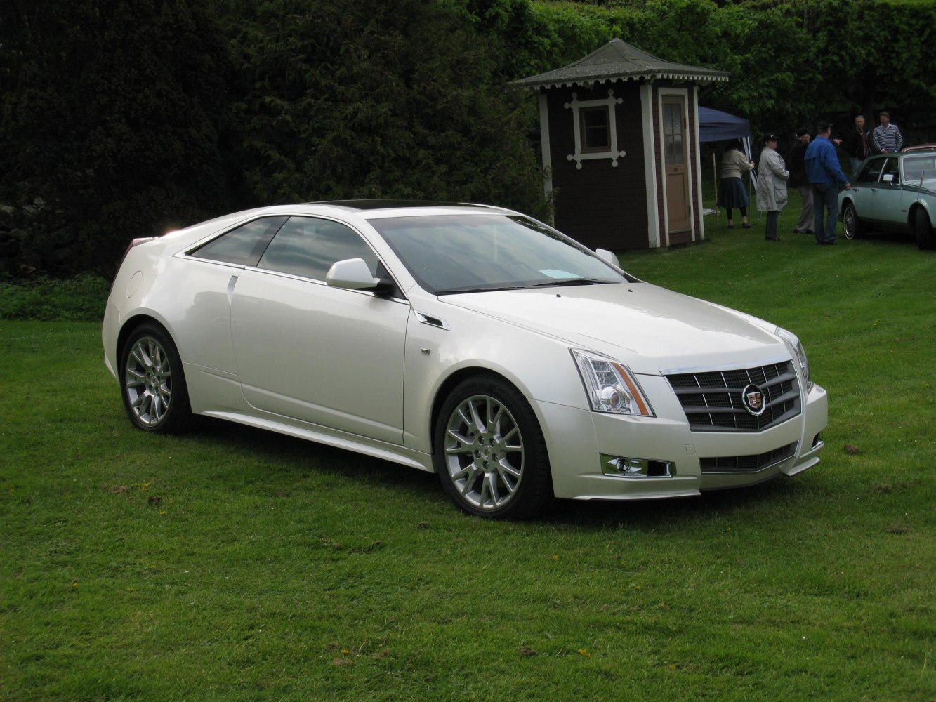 White luxury coupe with sharp front grille and alloy wheels