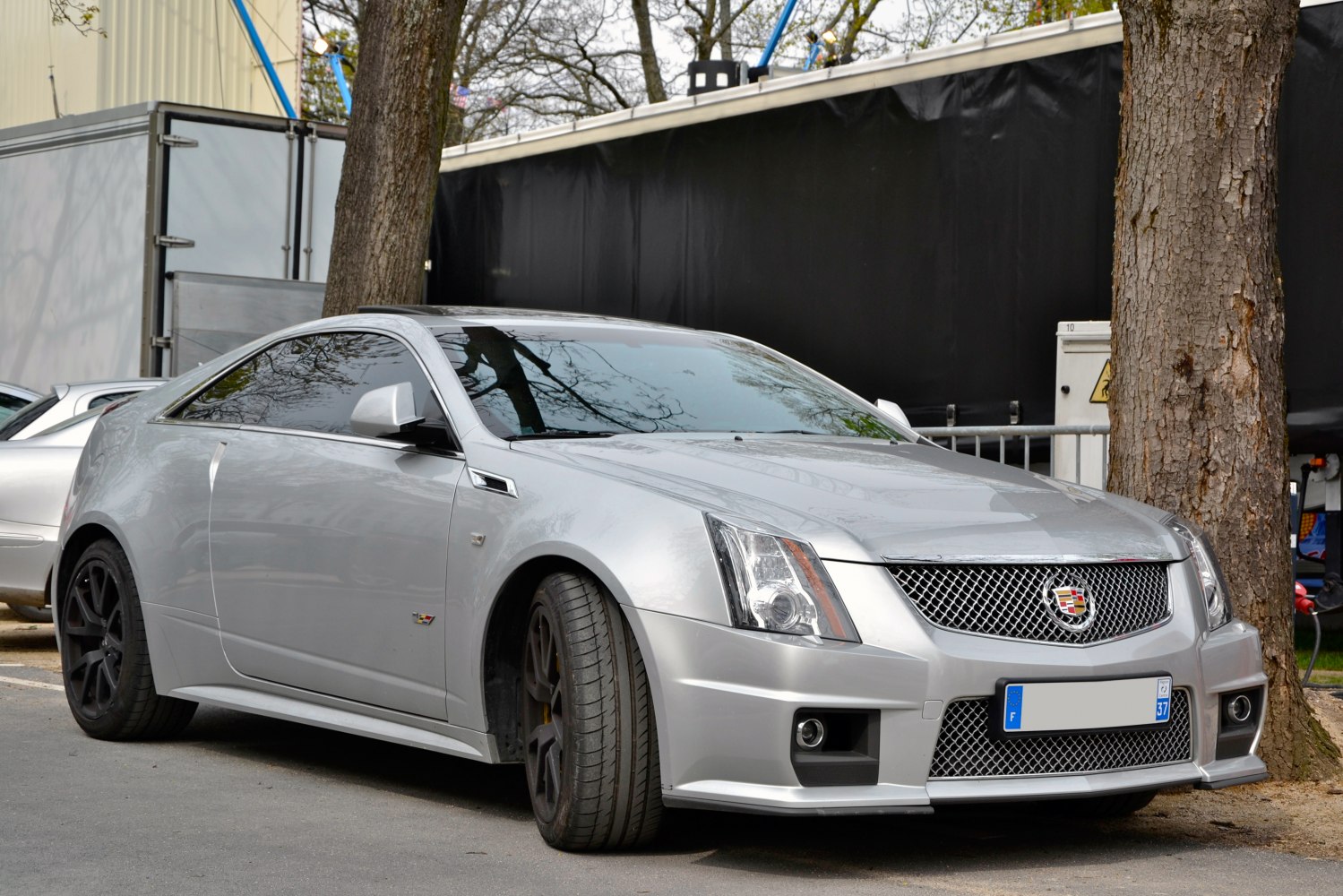 Silver sport coupe with aggressive front grille and aerodynamic body