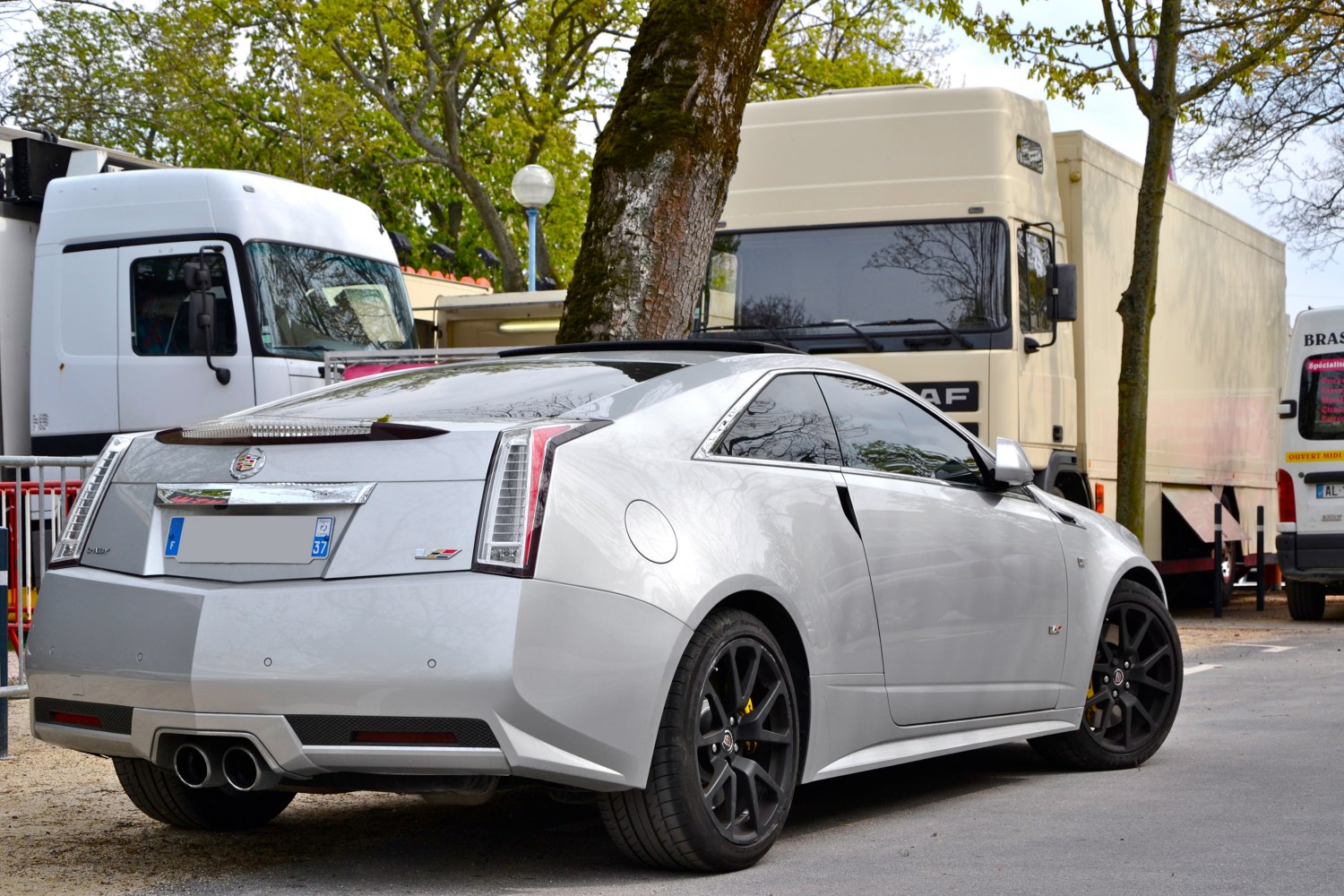 Rear view of coupe with dual exhaust and black alloy wheels