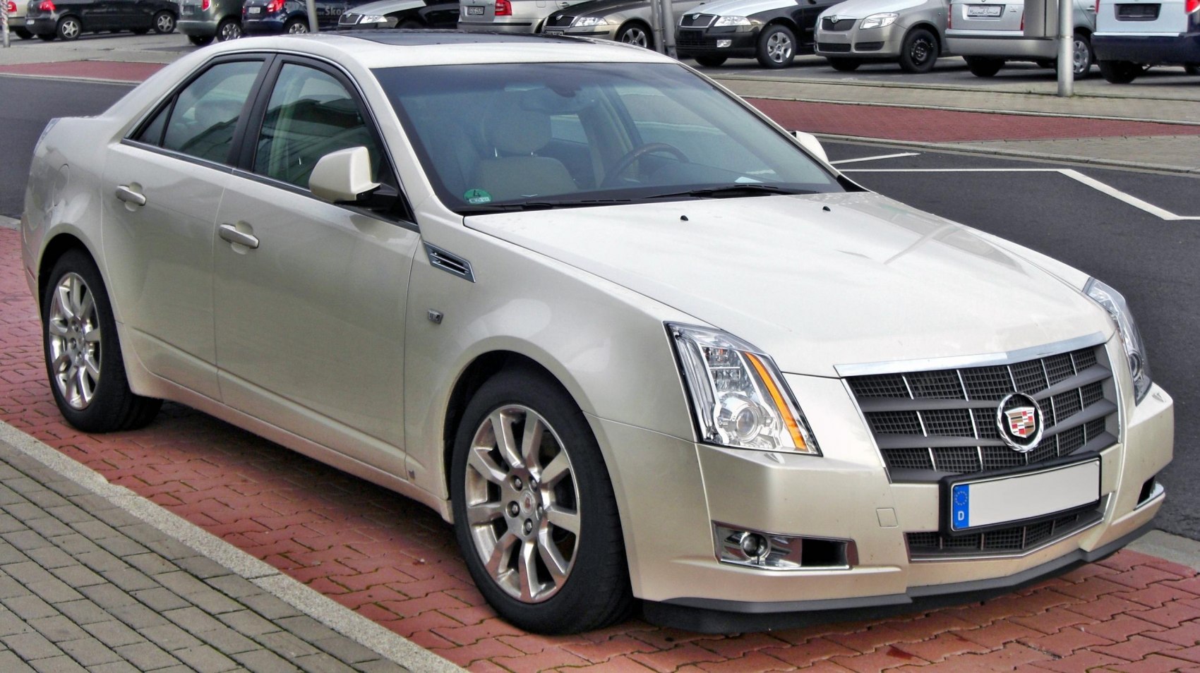 Front side of luxury sedan with grille, headlights, and alloy wheels