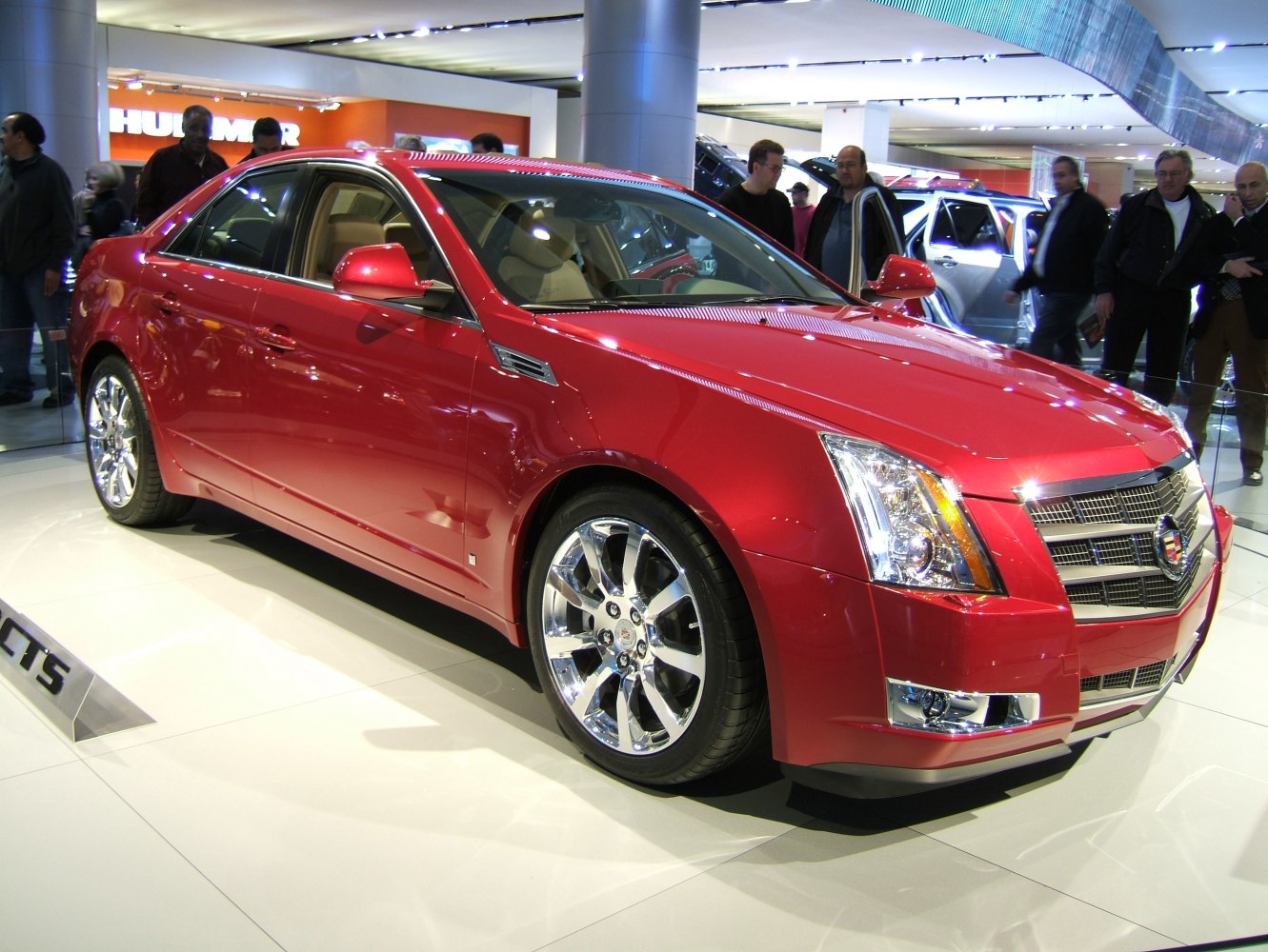 Red sedan with chrome wheels and sharp headlights