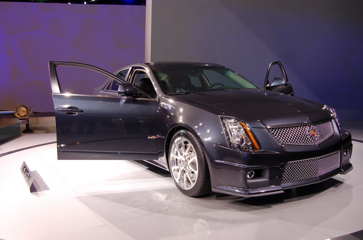 Front and side view with open doors of a dark luxury sedan