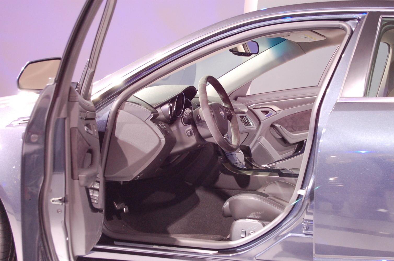 Car interior with open driver door and visible steering wheel