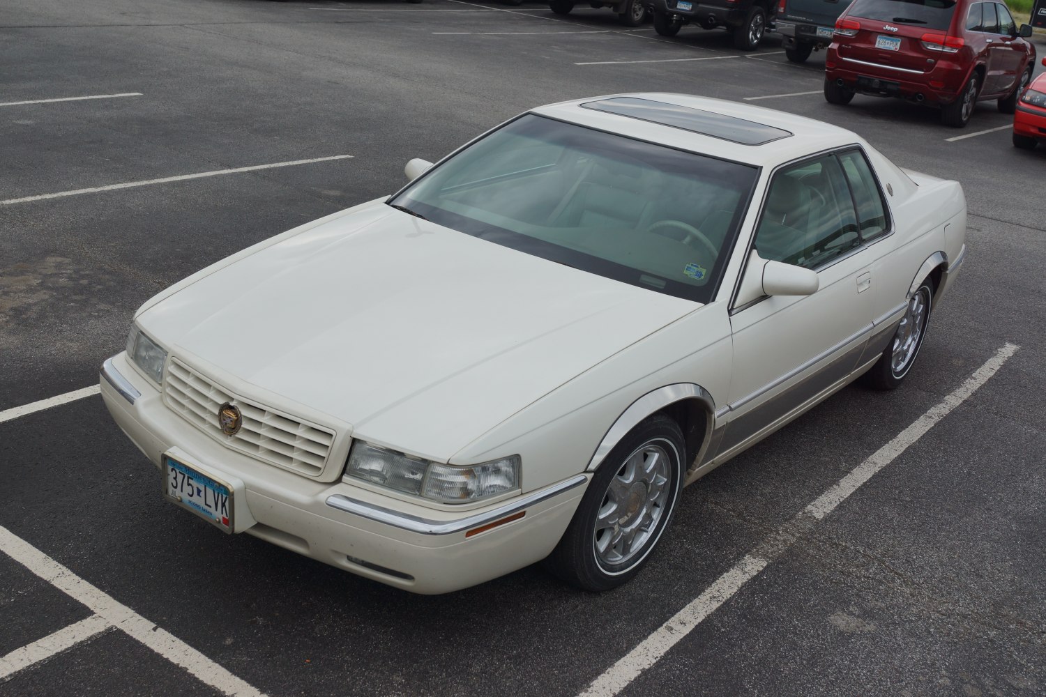 White luxury coupe with sunroof and chrome wheels
