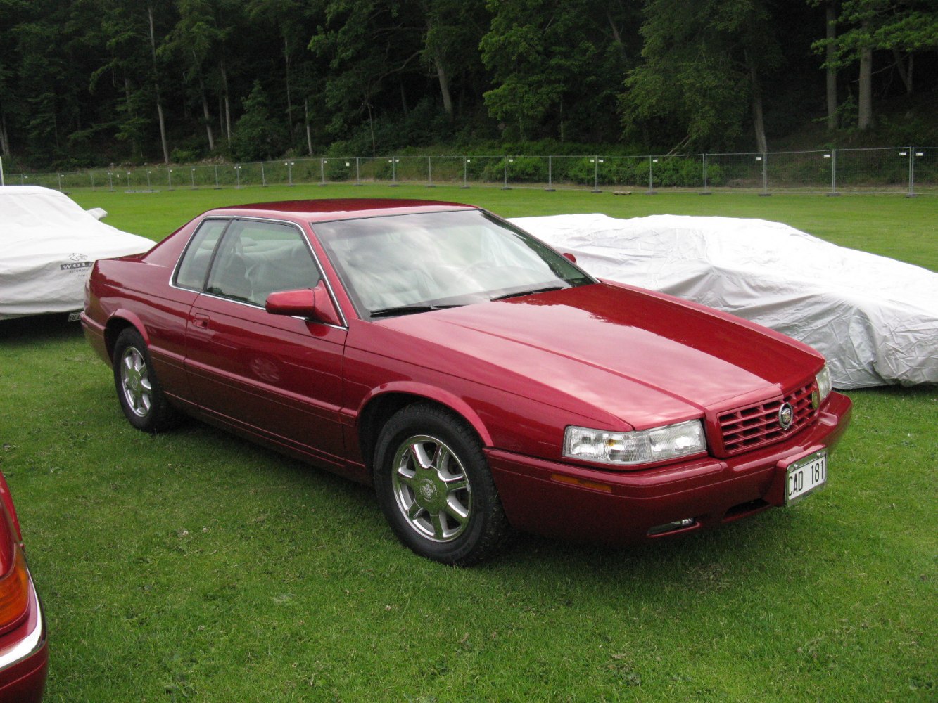 Red coupe with distinct front grille and chrome alloy wheels