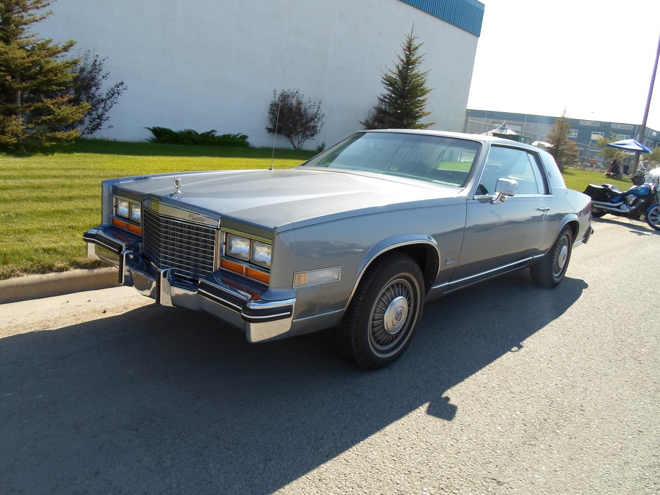 Vintage luxury coupe with wide grille, chrome bumper guards, square headlights
