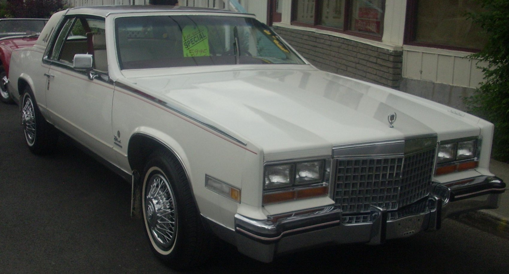White classic luxury coupe with chrome wire-spoke wheels