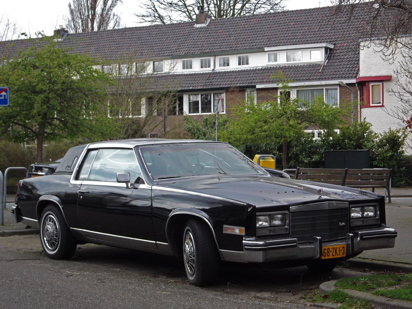 Black luxury coupe with vinyl roof and wire-spoke wheels